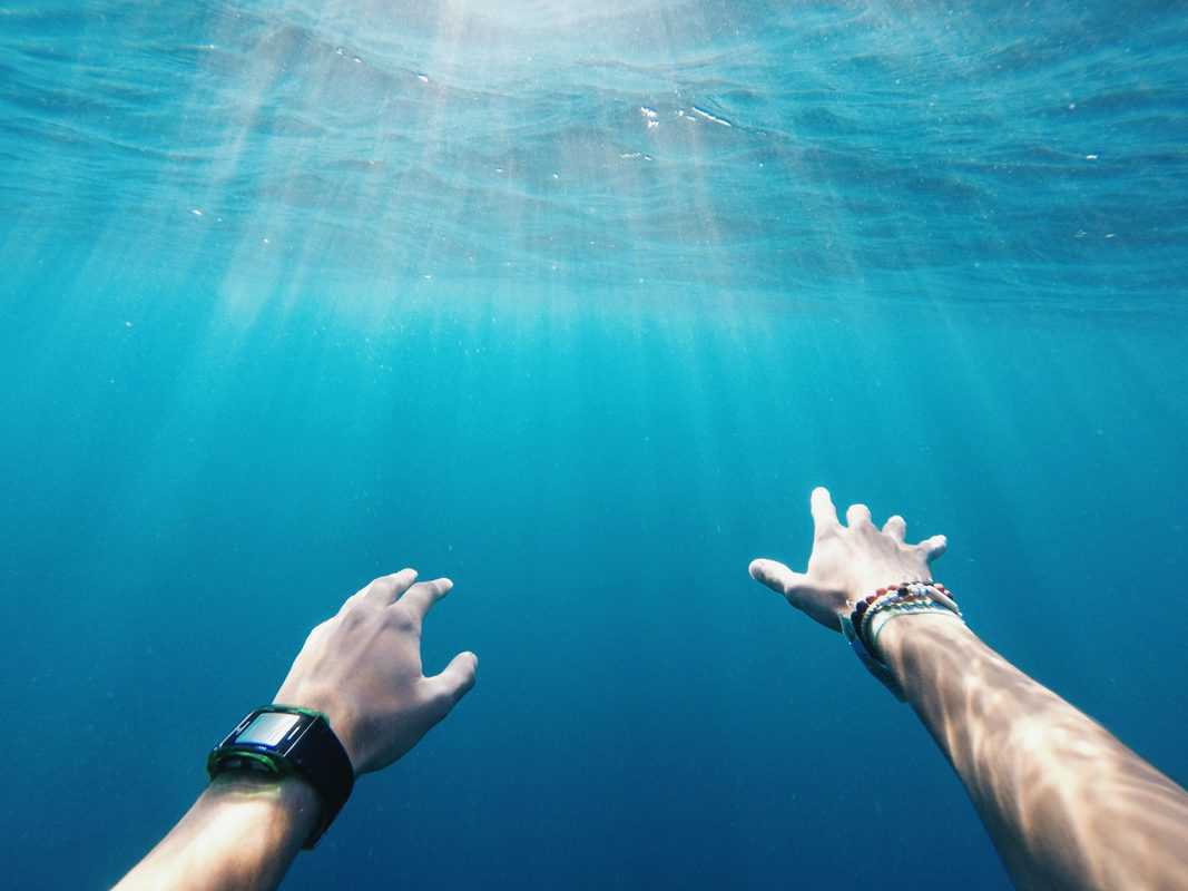 outstretched hands of underwater swimmer