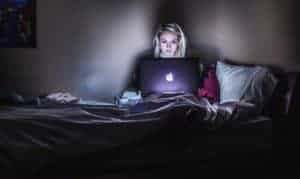 woman on computer sitting on a bed reading MyPoints Review