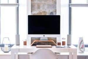 iMac desktop computer on a white desk in a brightly lit room