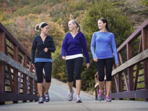 Three beautiful moms walking across a bridge while they are getting paid to walk