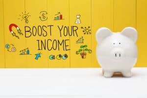increase your income boost your income Boost Yout Income text with piggy bank over yellow wall