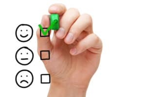 online focus groups Hand putting check mark with green marker on customer service evaluation form.
