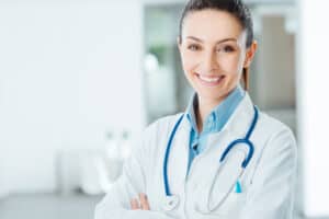 Jobs That Pay $100 An Hour Confident female doctor posing in her office and smiling at camera, health care and prevention concept