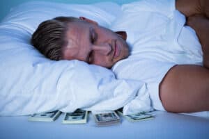 Get paid to sleep, man sleeping on cash under pillow