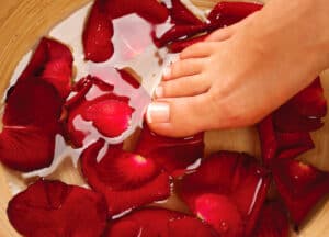 Feetify Review Feet Spa. Pedicure. Female legs in water with rose petals