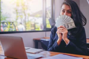 How To Make $1000 A Week happy woman with dollars money in her hand.